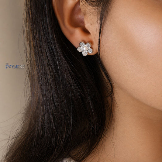 Close-up of a person wearing a floral earring with a blurred background