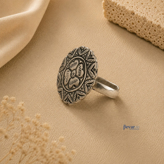 pevar925 oxidized silver adjustable ring featuring a round floral chitai engraving on a neutral textured background.