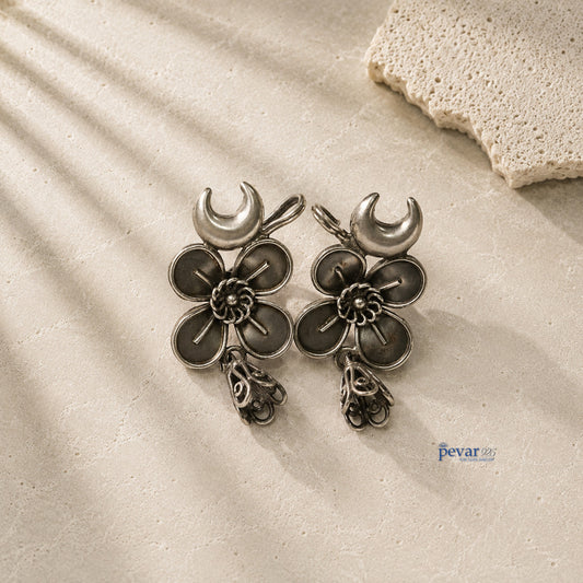 pevar925 oxidized 925 silver ear cuffs featuring crescent moon and flower motifs with dangling jhumkis on stone surface