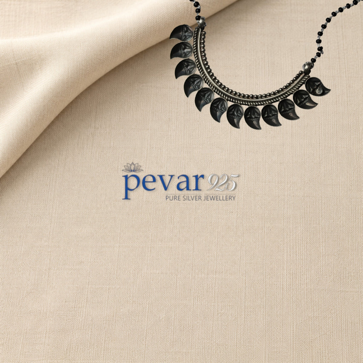 pevar925 oxidized 925 sterling silver mangalsutra with black beads and a crescent leaf pendant on beige fabric