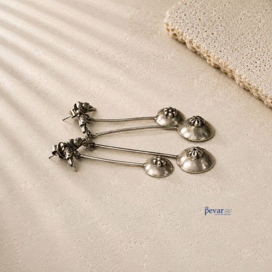 pevar925 oxidized 925 silver sparrow drop earrings with vintage antique finish on a textured beige surface