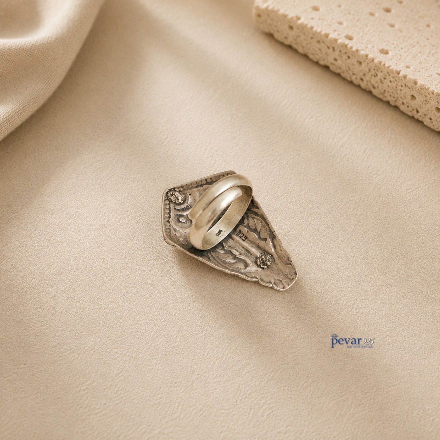 pevar925 oxidized silver adjustable ring with intricate tower motif chitai engraving on a neutral textured background