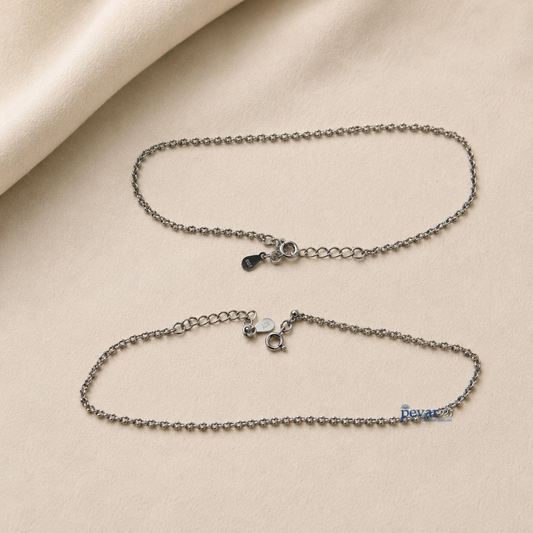 Two pevar925 sterling silver chain anklets with lobster clasps and adjustable extensions on a beige fabric background.