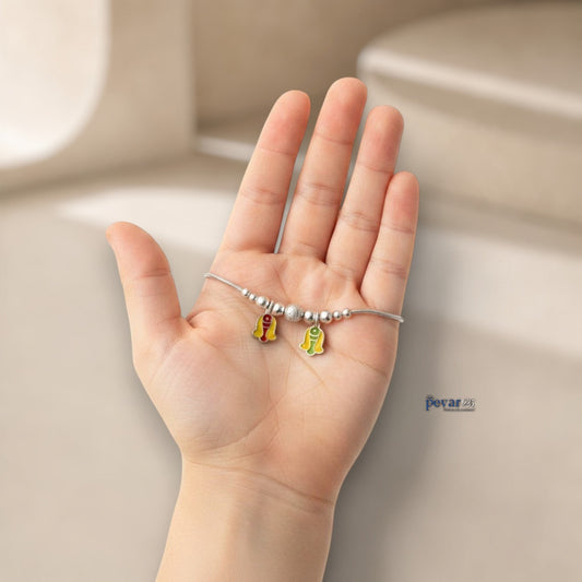 pevar925 sterling silver kids bracelet featuring colorful enamel twin fish charms and silver beads held in a hand