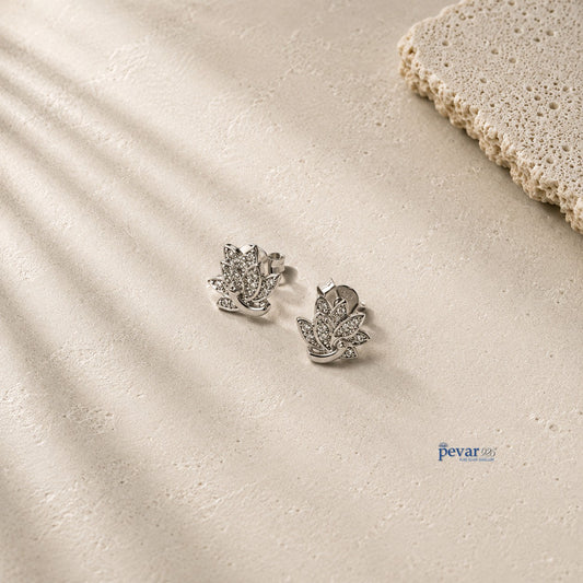 pevar925 sterling silver lotus stud earrings with rhodium plating and intricate detailing on a textured beige surface