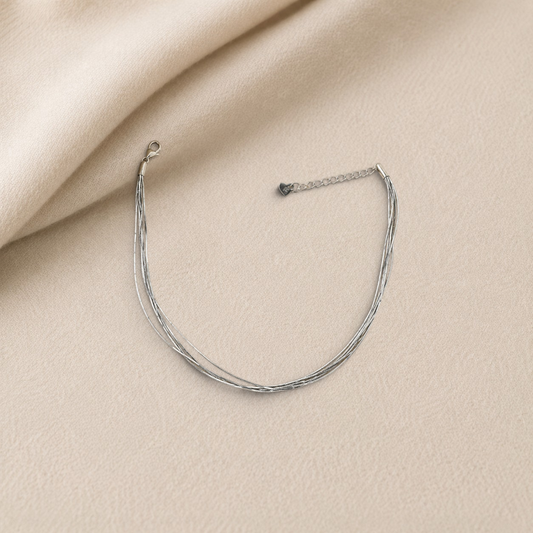 pevar925 sterling silver multi-strand anklet with a delicate heart-tag charm on a soft beige fabric background