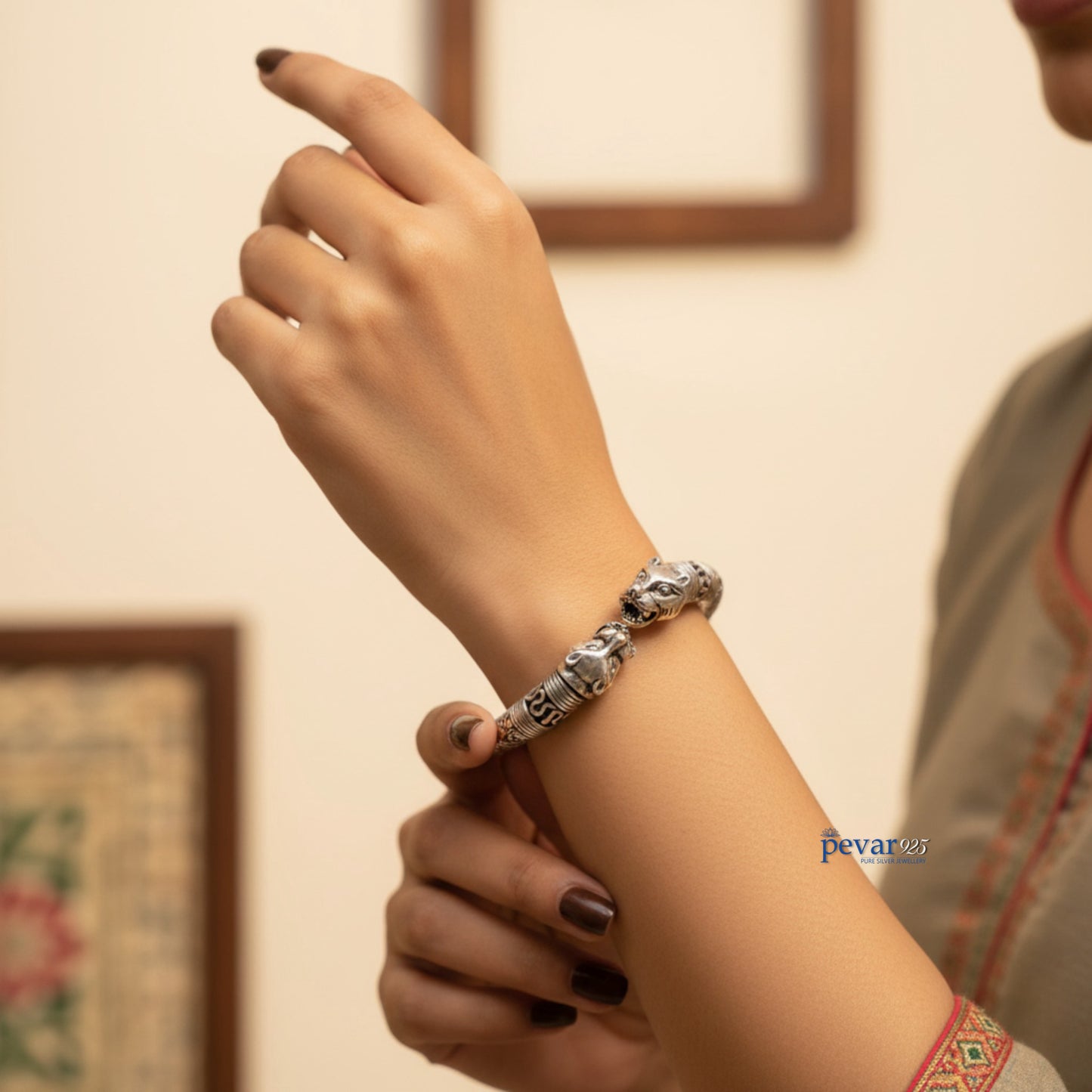 Hand wearing a silver bracelet with a blurred background