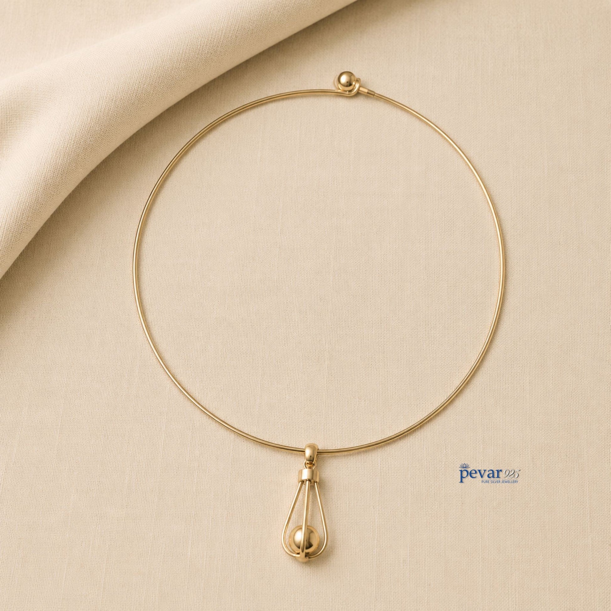 pevar925 gold-toned hasli necklace featuring a minimalist circular band and an elongated cage pendant with a bead.