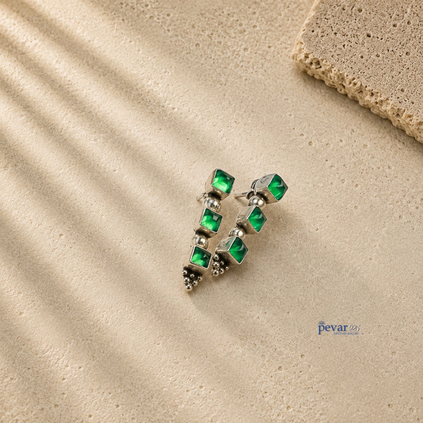 pevar925 oxidized 925 silver trio earrings featuring three square emerald green stones on a textured beige surface