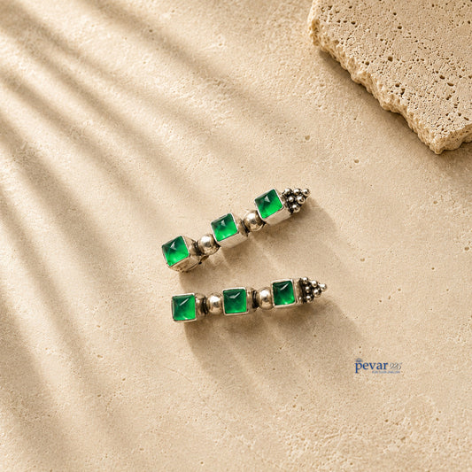pevar925 oxidized 925 silver trio earrings featuring three square green emerald-colored stones on a textured surface