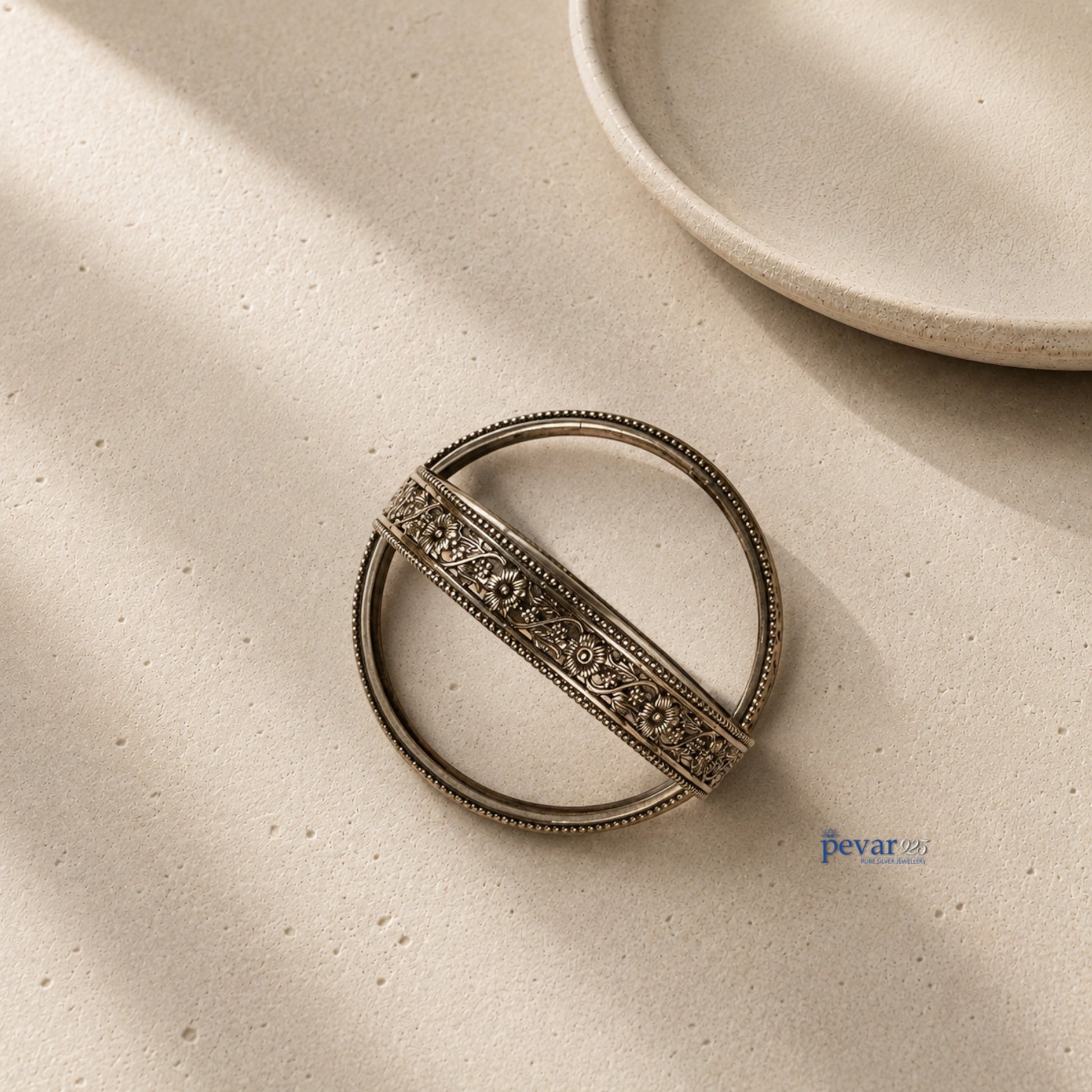 pevar925 oxidized 925 sterling silver bangle featuring intricate floral vine engravings and a beaded rim on a neutral base.