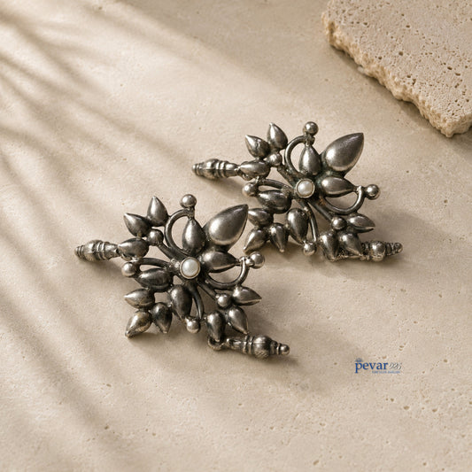 pevar925 oxidized 925 silver ear cuffs featuring large floral motifs with central pearl accents on a textured surface.