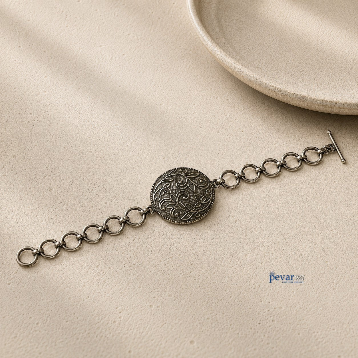 pevar925 oxidized 925 sterling silver bracelet featuring a round floral medallion with intricate vine engravings.