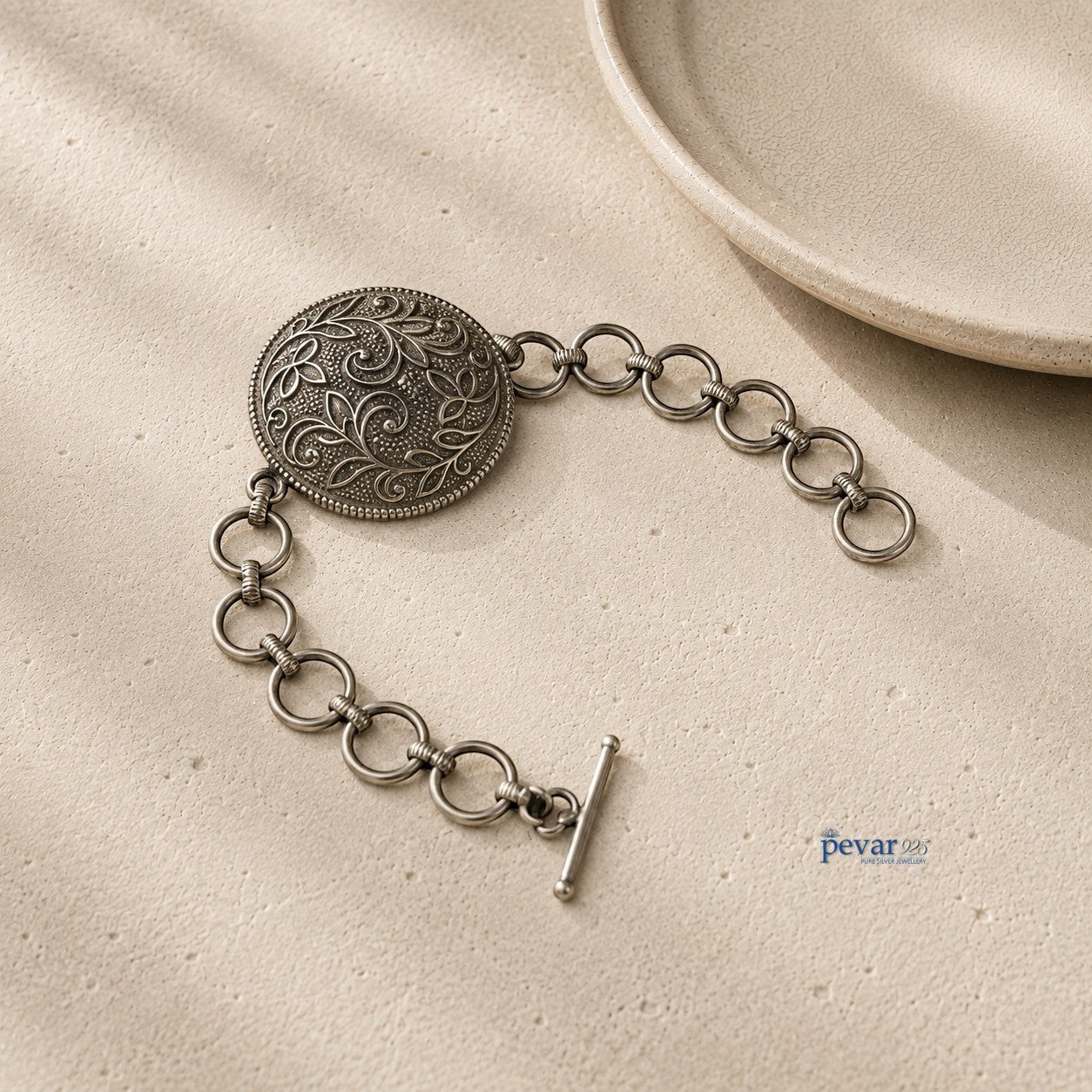 pevar925 oxidized 925 sterling silver bracelet featuring a round floral medallion with intricate vine engravings.