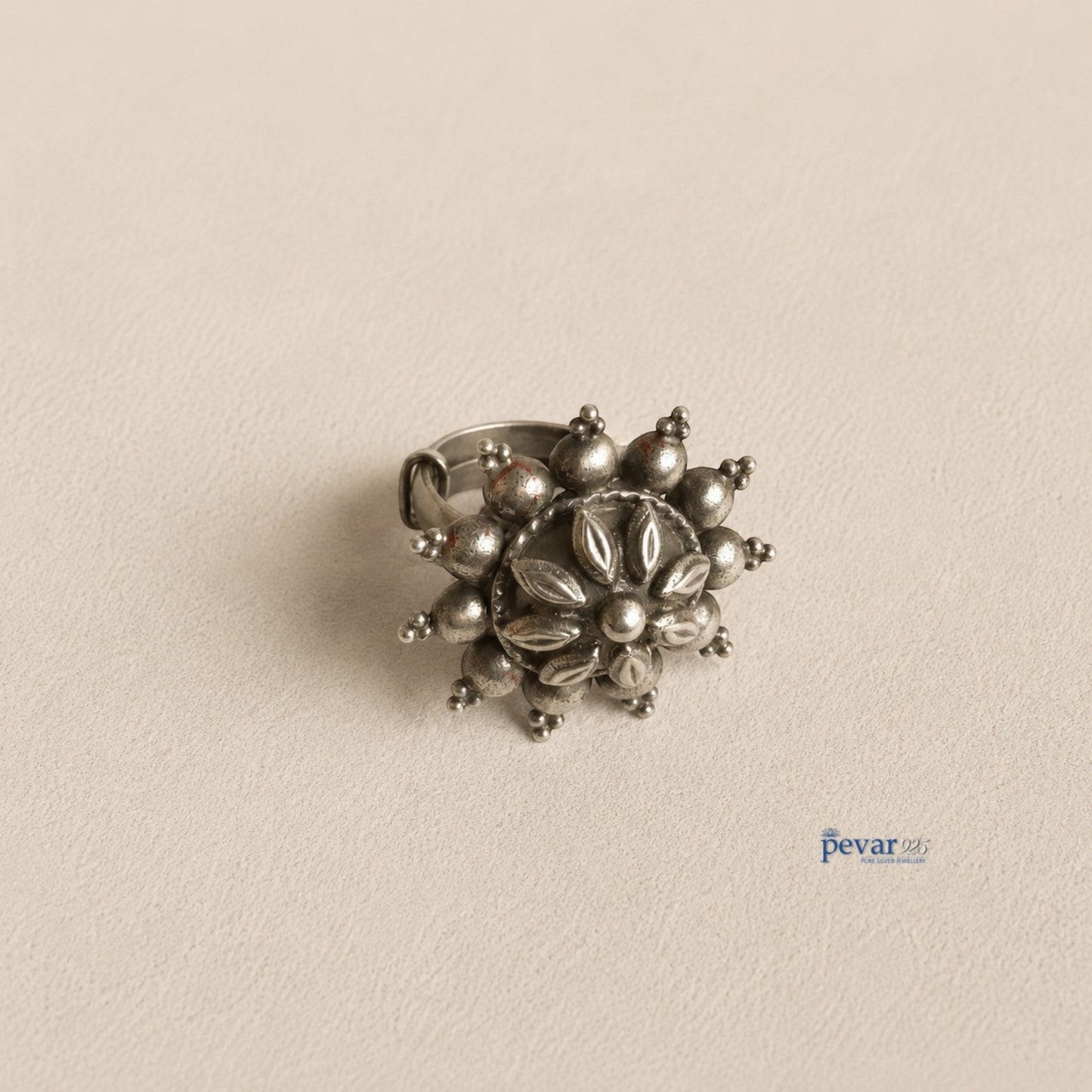 pevar925 oxidized sterling silver adjustable ring featuring a circular floral motif with intricate petal engravings.