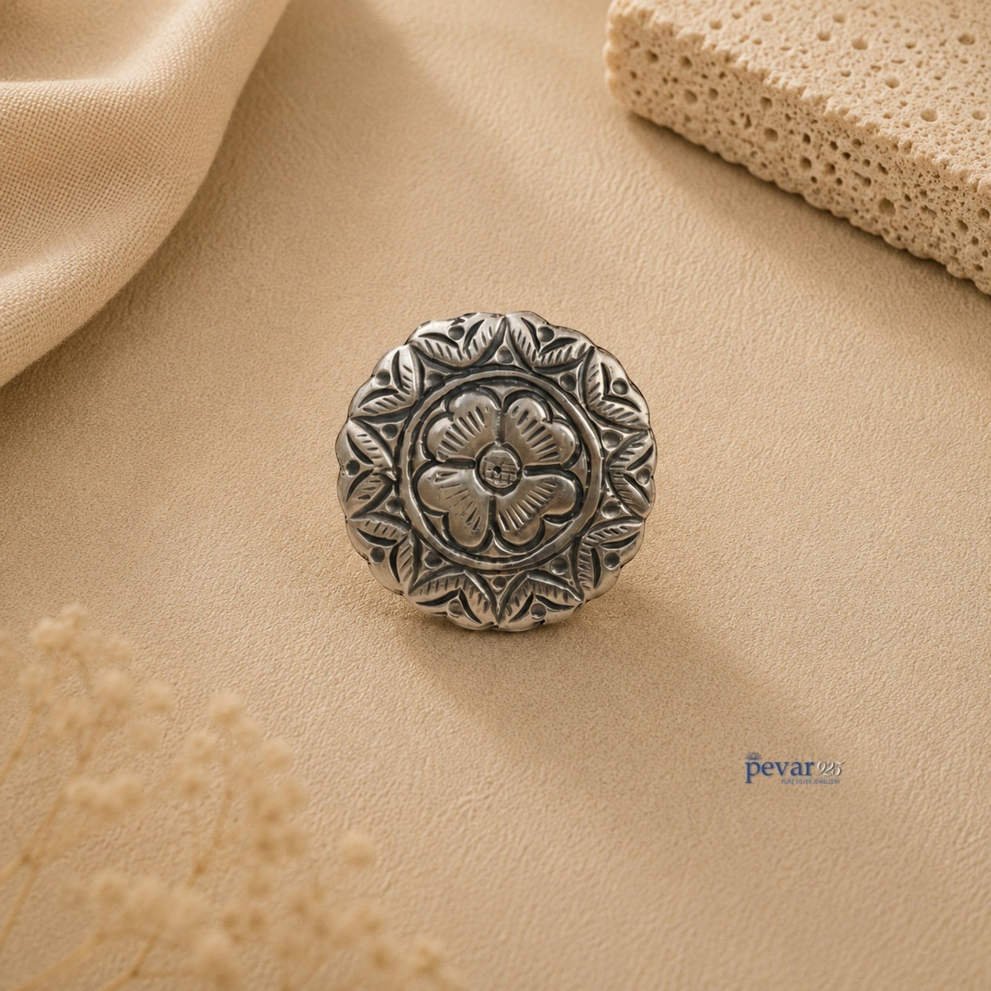 pevar925 oxidized silver adjustable ring featuring a round floral chitai design on a textured beige background.