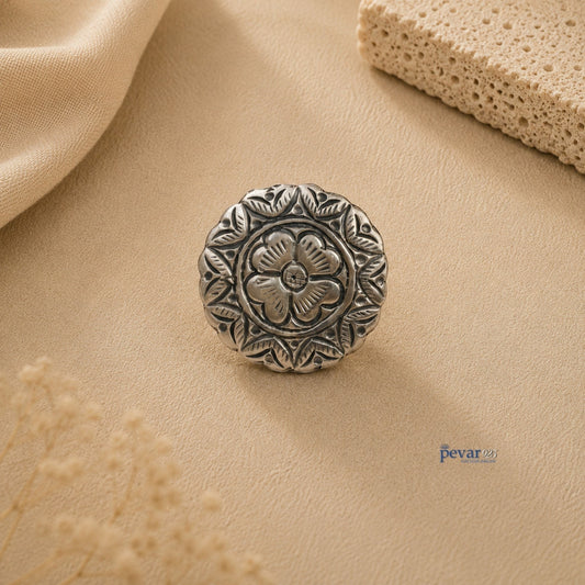 pevar925 oxidized silver adjustable ring featuring a round floral chitai design on a textured beige background.