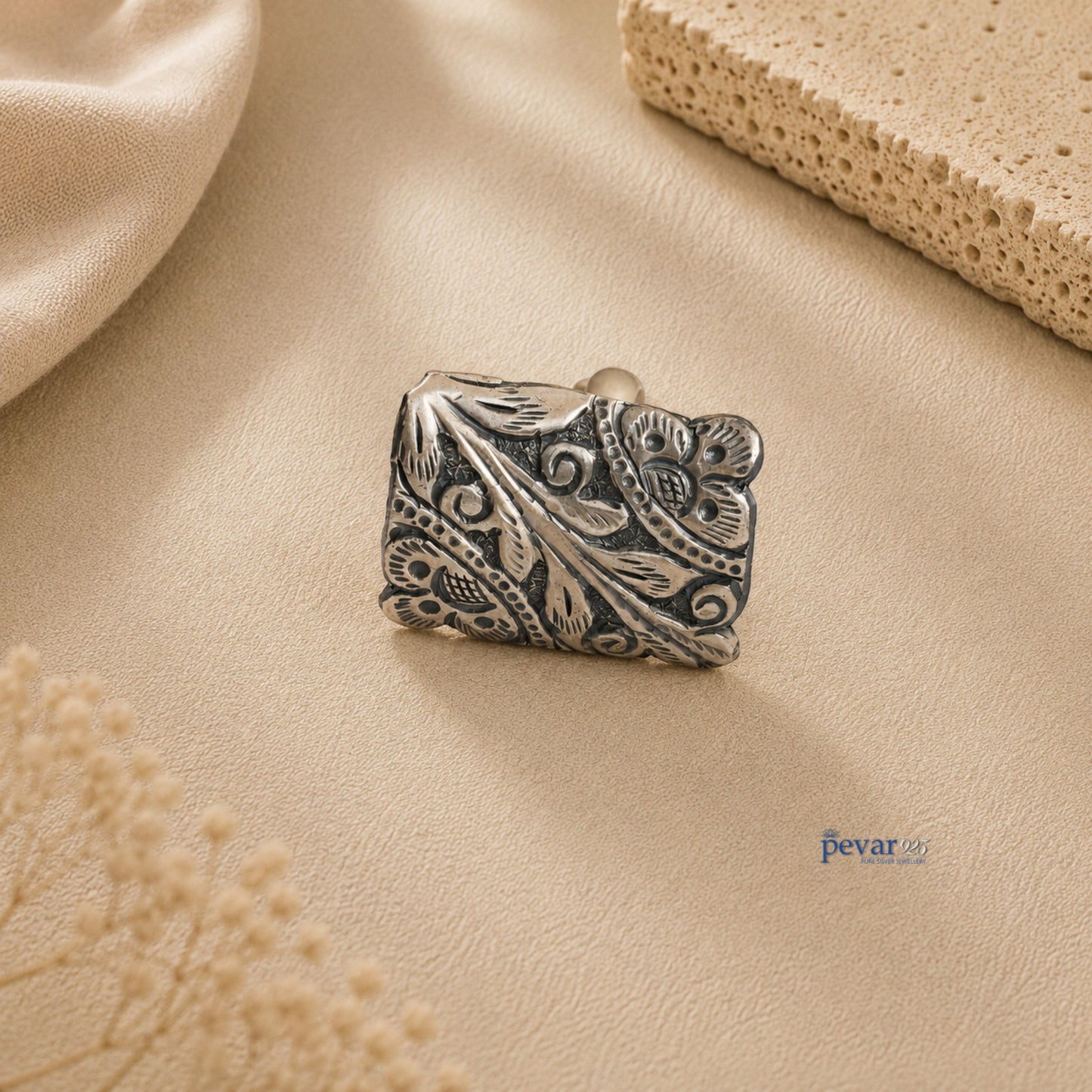 pevar925 oxidized silver rectangular ring featuring intricate floral chitai engraving on a textured beige background