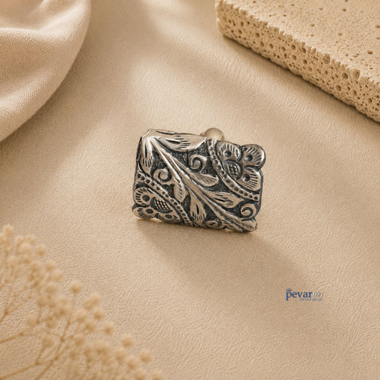 pevar925 oxidized silver rectangular ring featuring intricate floral chitai engraving on a textured beige background