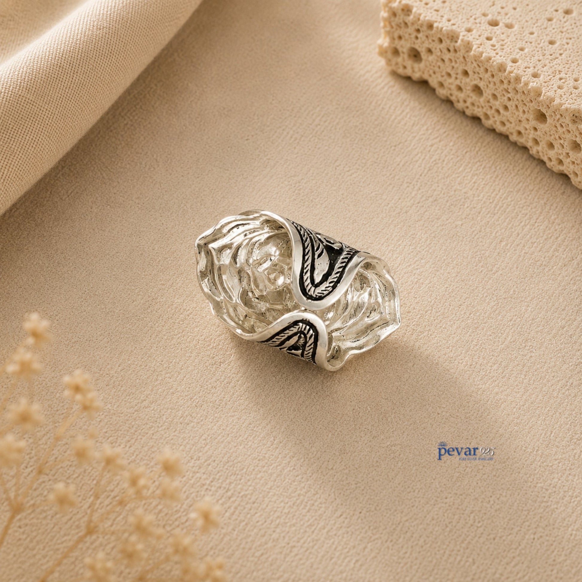 pevar925 oxidized silver adjustable ring featuring intricate floral chitai engraving on a textured beige background