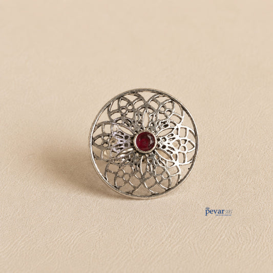 pevar925 oxidized sterling silver adjustable ring featuring a circular floral filigree motif with a central red stone.