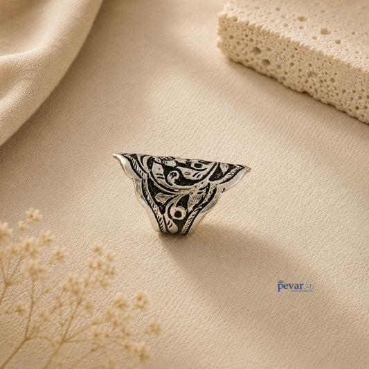 pevar925 oxidized silver adjustable ring featuring intricate traditional floral and leaf chitai engraving on a beige surface