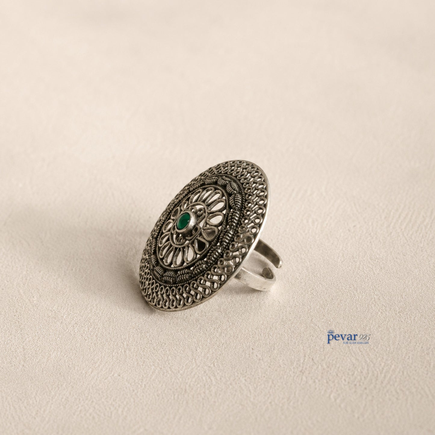 pevar925 oxidized sterling silver adjustable ring featuring a circular floral filigree motif and a central green stone.