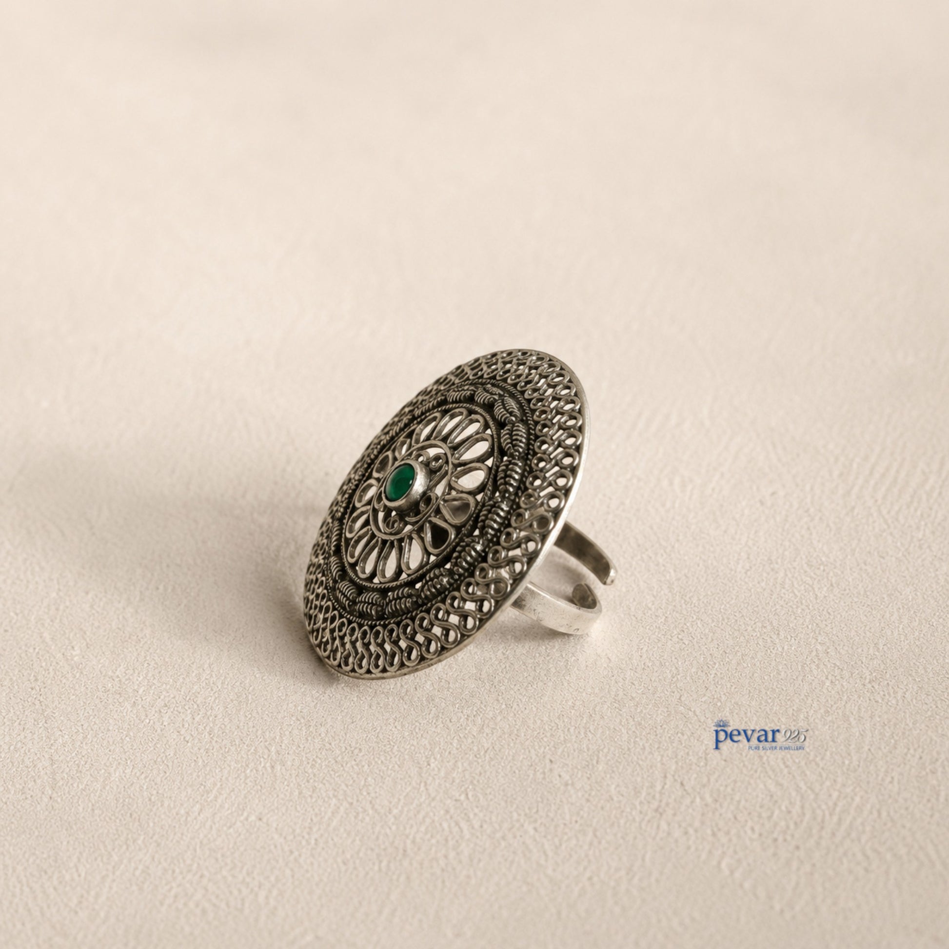 pevar925 oxidized sterling silver adjustable ring featuring a circular floral filigree motif and a central green stone.