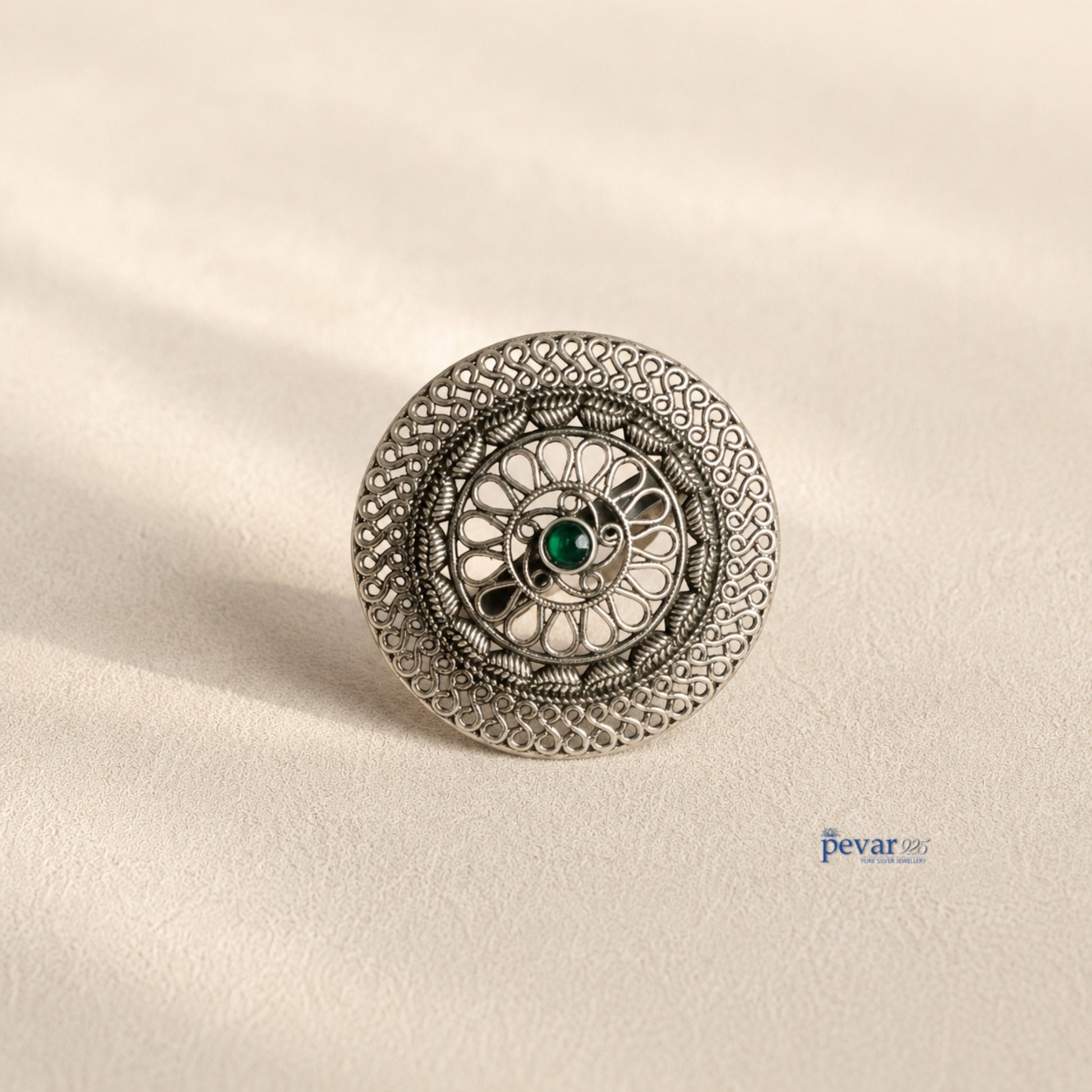 pevar925 oxidized sterling silver adjustable ring featuring a circular floral filigree motif and a central green stone.