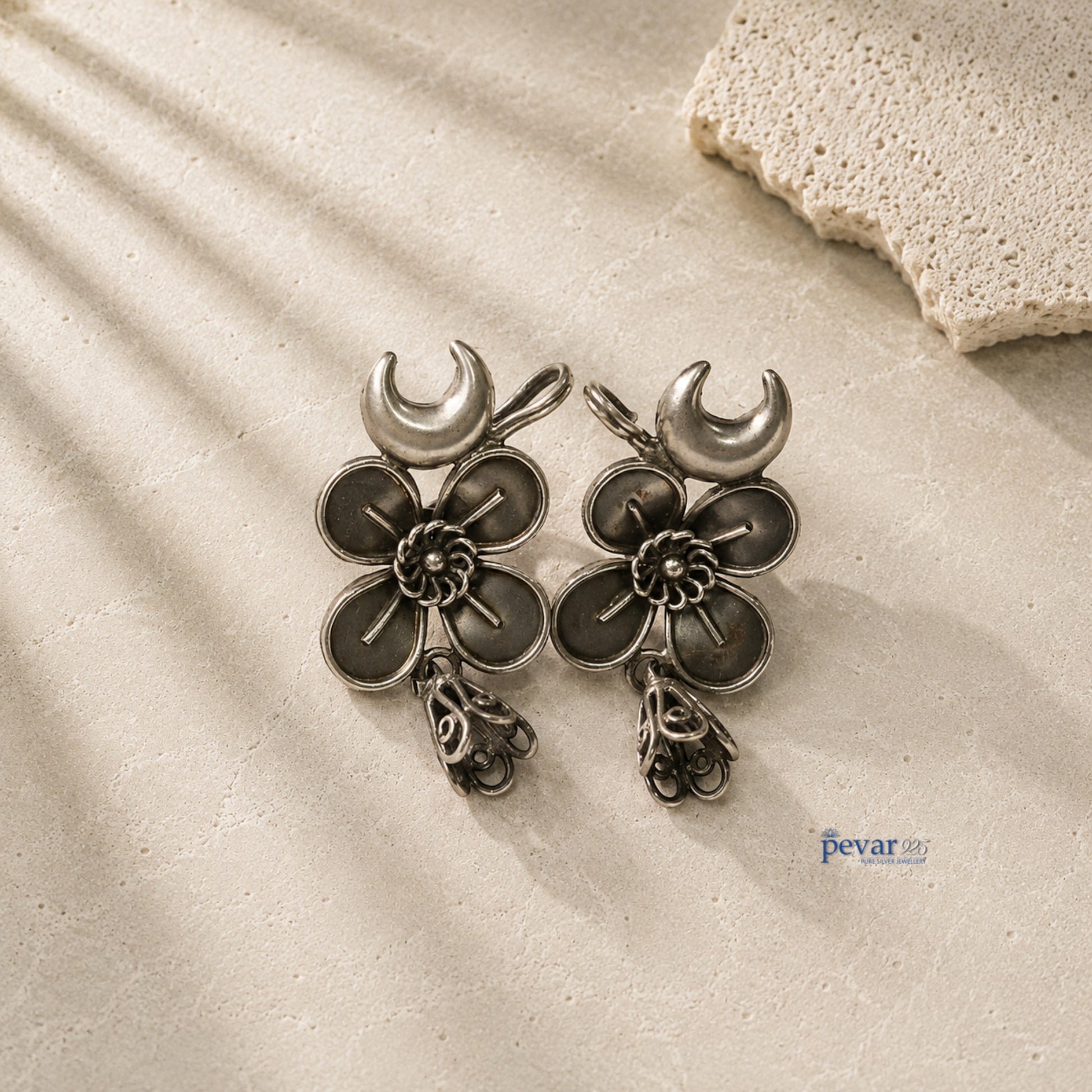 pevar925 oxidized 925 silver ear cuffs featuring crescent moon and flower motifs with dangling jhumkis on stone surface