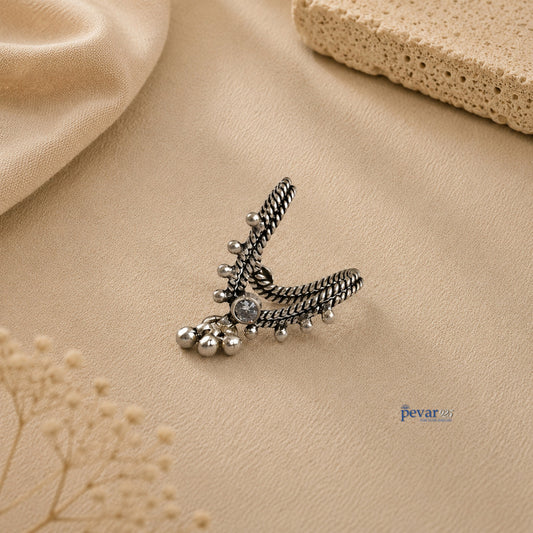 pevar925 oxidized silver V-shaped adjustable ring with central stone and dangling ghunghroo beads on beige background