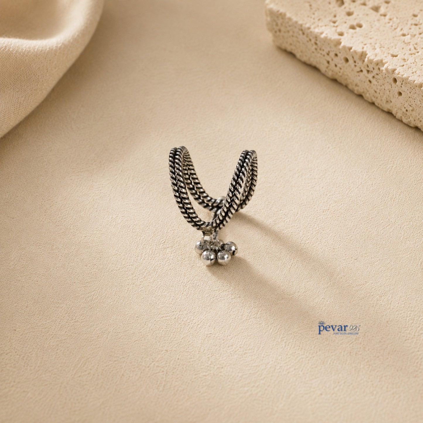 pevar925 oxidized 925 sterling silver V-shaped ring with traditional ghunghroo beads on a textured beige background