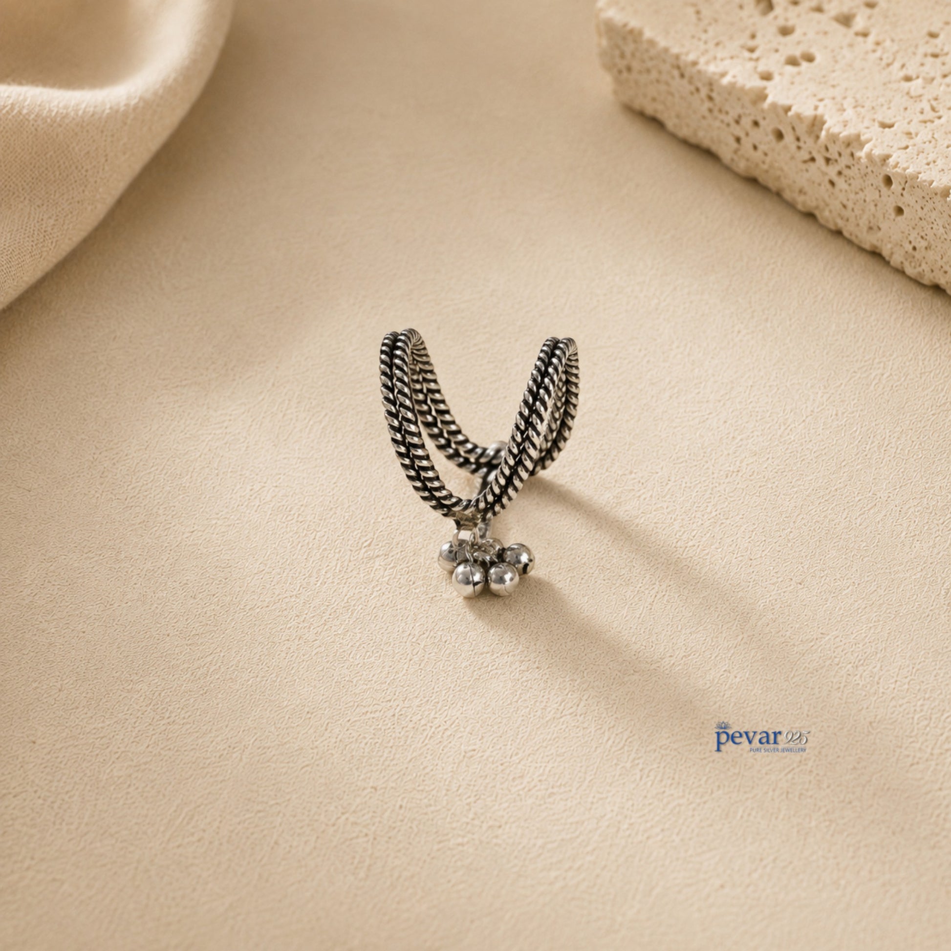pevar925 oxidized 925 sterling silver V-shaped ring with traditional ghunghroo beads on a textured beige background