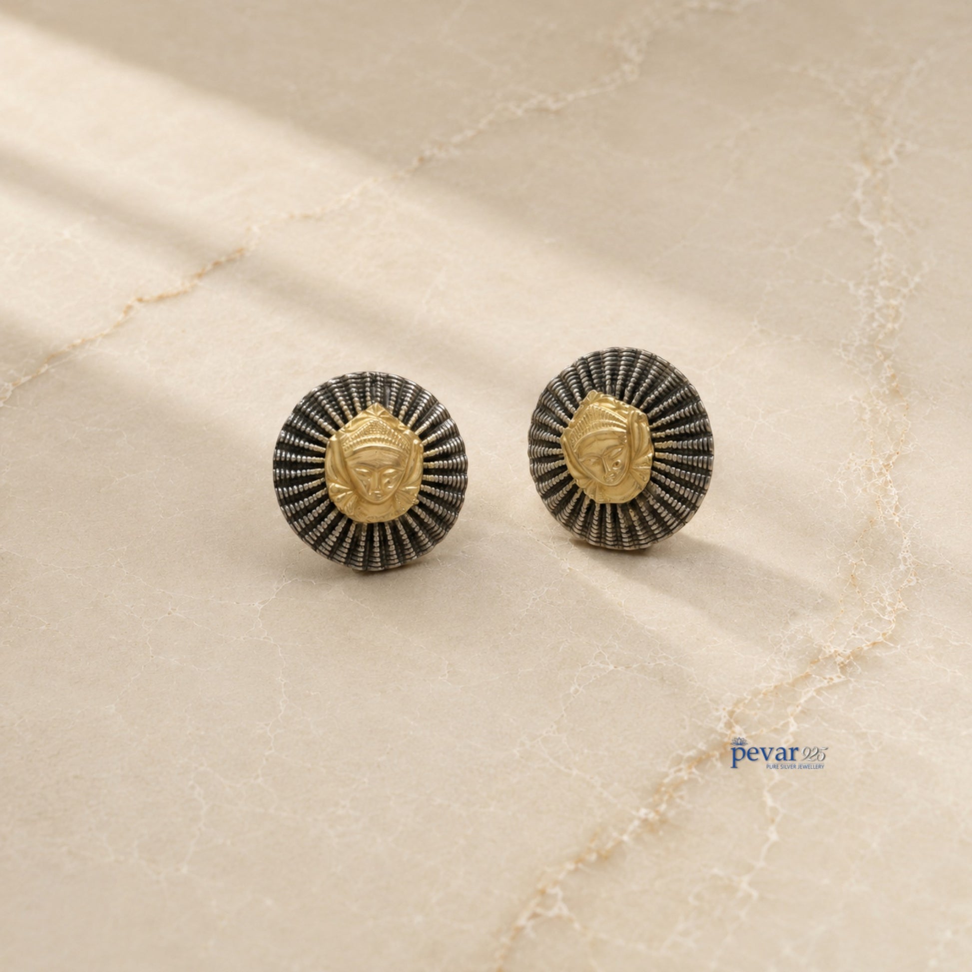 pevar925 oxidized silver statement earrings featuring a round ridged frame and a central golden goddess face motif.