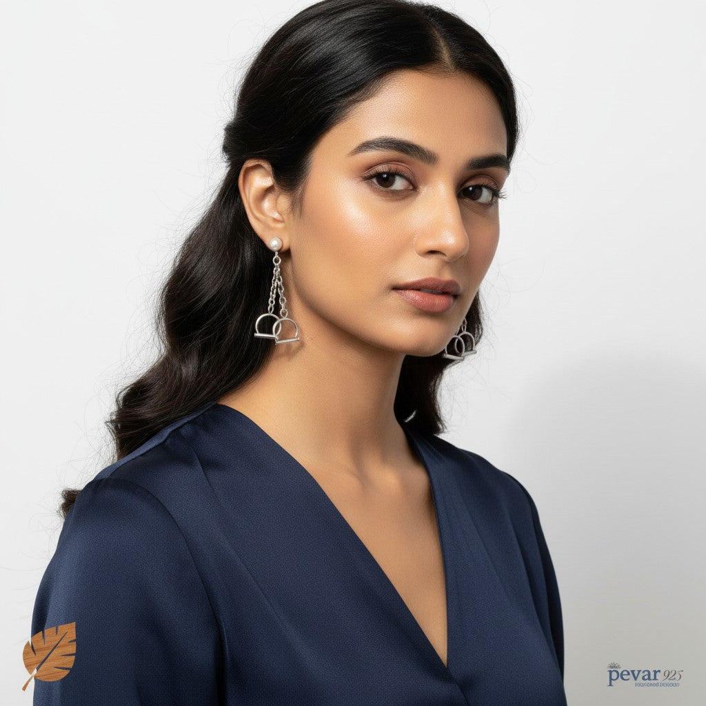 A model wearing pevar925 oxidized 925 sterling silver handcuffs earrings with a chain drop design.