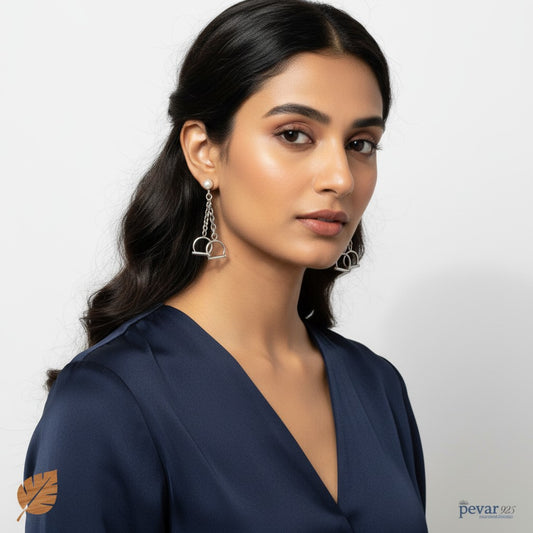 A model wearing pevar925 oxidized 925 sterling silver handcuffs earrings with a chain drop design.