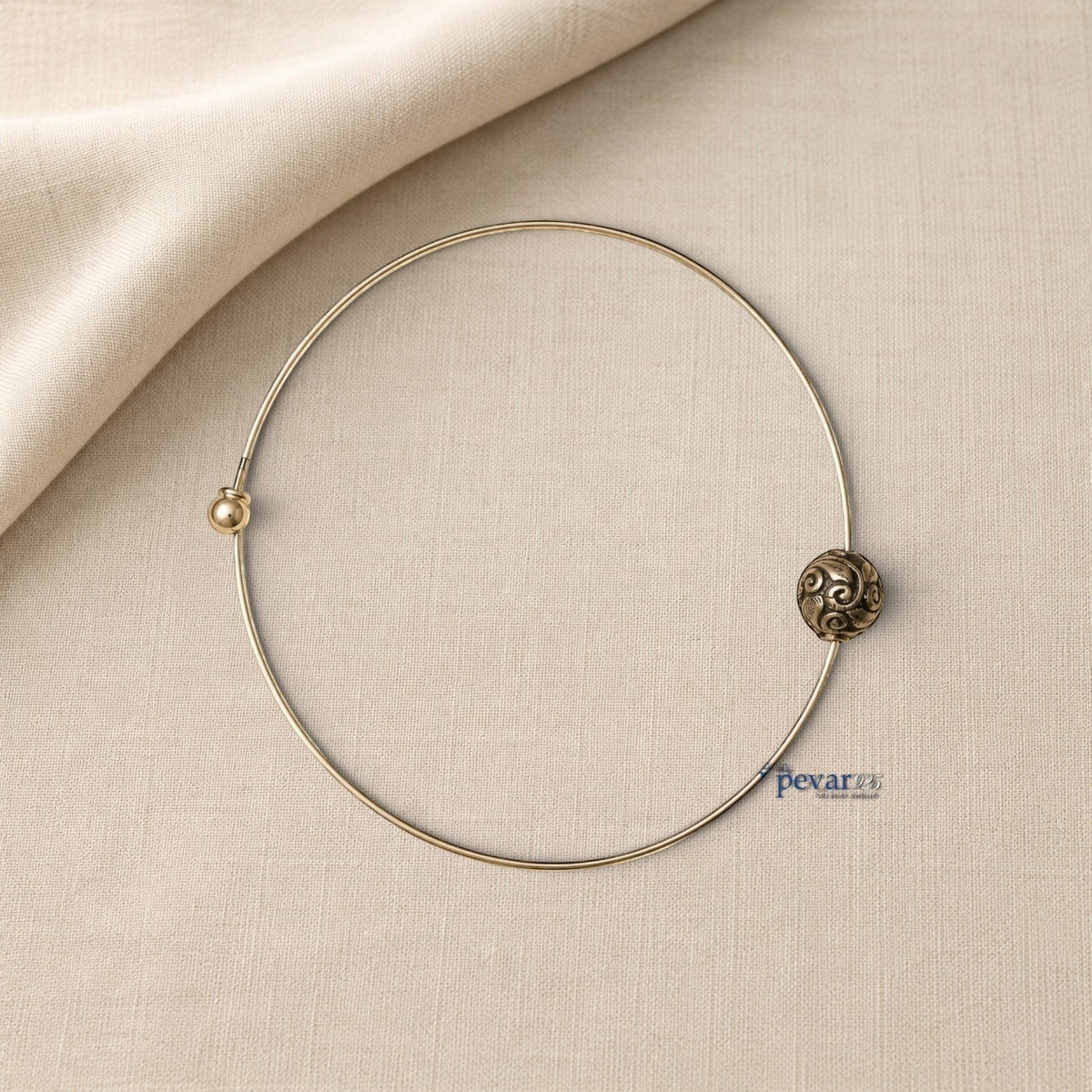 pevar925 oxidized silver hasli necklace with a central ornate bead featuring intricate swirl patterns on beige fabric