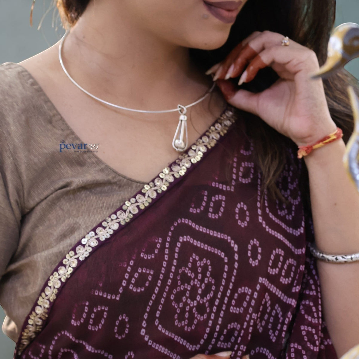 pevar925 oxidized silver hasli necklace with a long cage pendant worn by a woman in a traditional maroon saree
