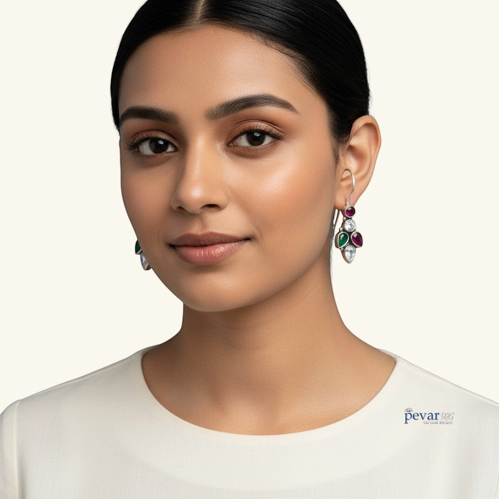 Model wearing pevar925 oxidized 925 silver earrings featuring colorful leaf motifs with red and green accents.