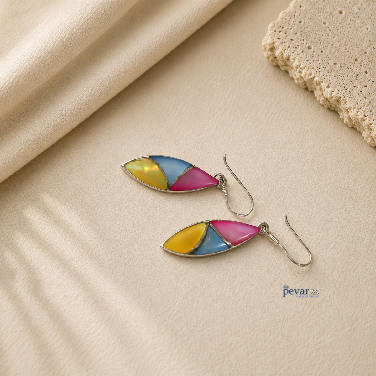 pevar925 oxidized silver hook earrings featuring vibrant tri-color leaf motifs in yellow, blue, and pink on beige fabric.