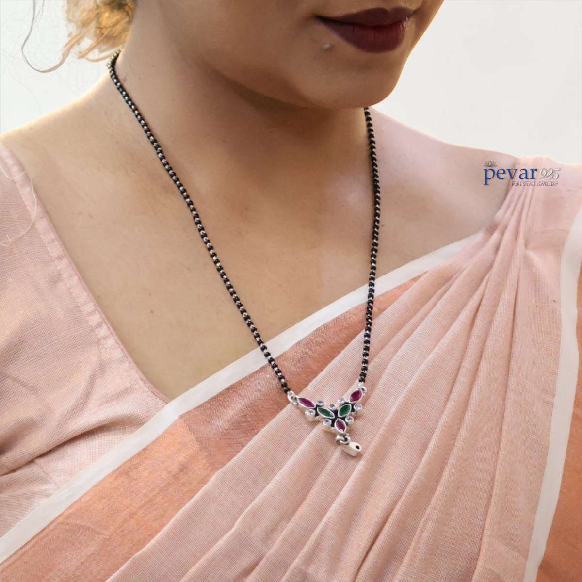 pevar925 oxidized 925 silver mangalsutra with black beads and a maroon and green leaf motif pendant on a woman