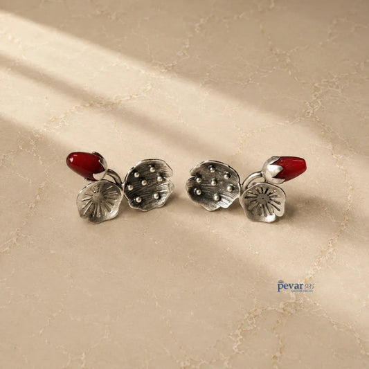 pevar925 oxidized 925 silver lotus earrings with vibrant red beads on a textured surface