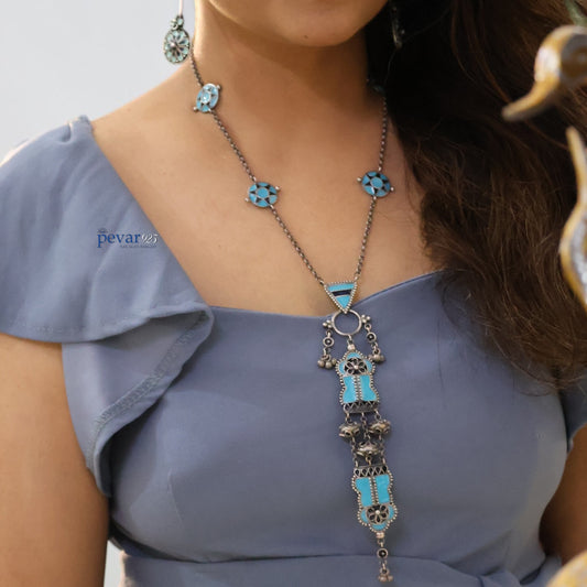 Woman wearing a pevar925 handcrafted 925 oxidized silver lotus bloom minakari necklace with vibrant blue enamel accents