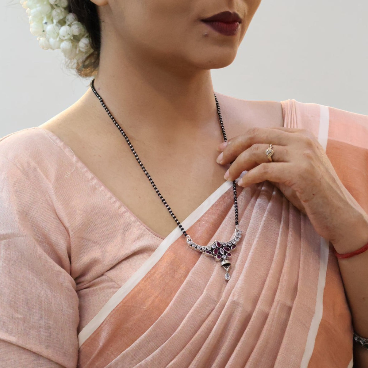 pevar925 oxidized sterling silver mangalsutra with black beads, maroon stones, and a heritage floral pendant on a model