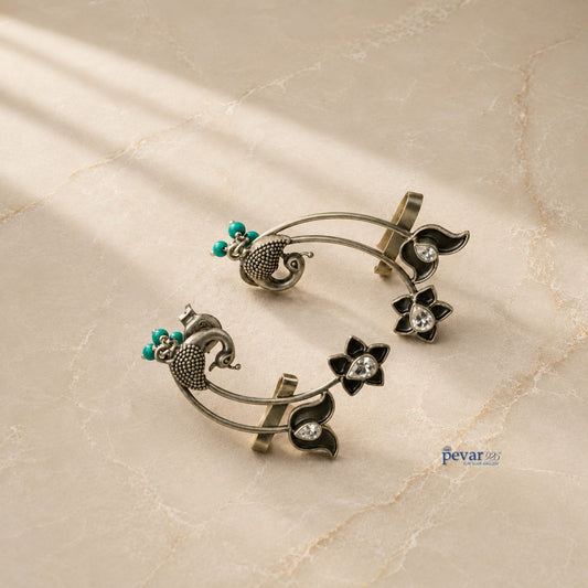 pevar925 oxidized 925 silver ear cuffs featuring peacock and lotus motifs with turquoise bead accents.
