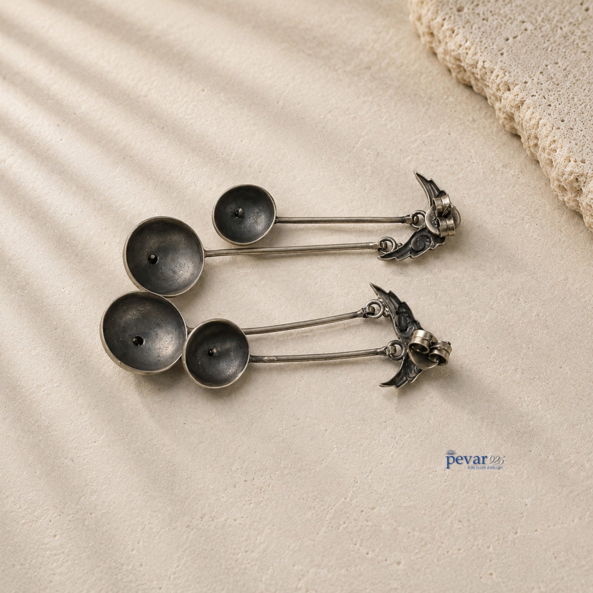 pevar925 oxidized 925 silver sparrow drop earrings with vintage antique finish on a textured beige surface