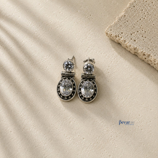 pevar925 oxidized 925 silver hook earrings featuring sparkling oval stones on a textured stone surface.