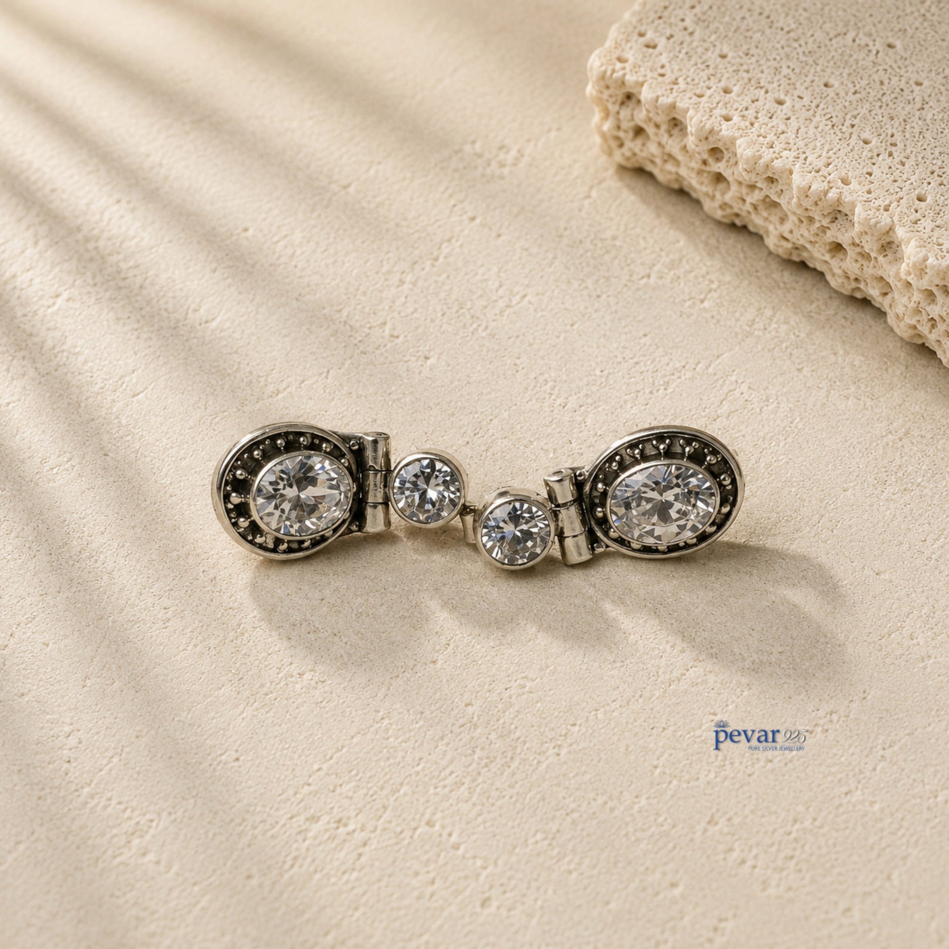 pevar925 oxidized 925 silver hook earrings featuring sparkling round stones on a textured stone surface