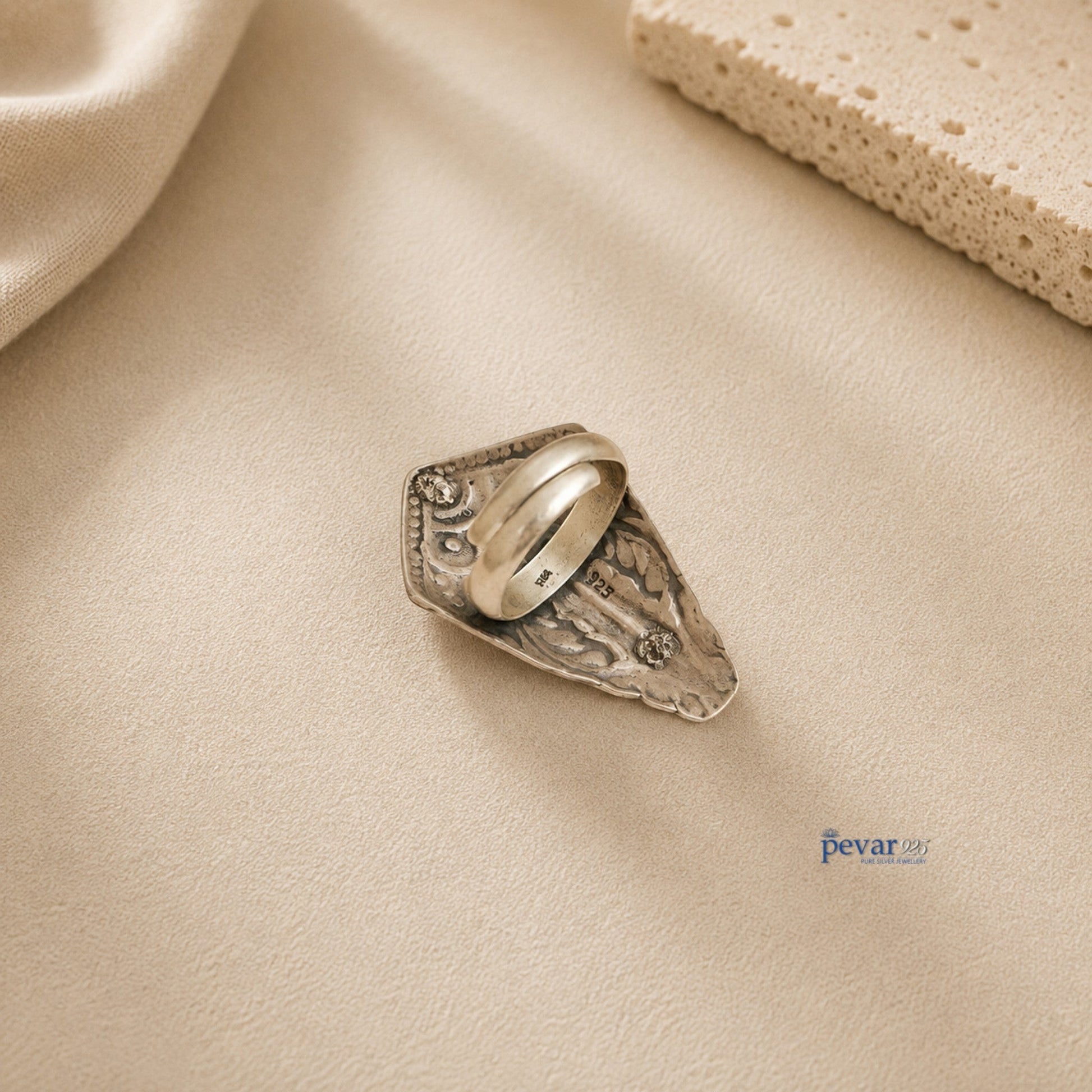 pevar925 oxidized silver adjustable ring with intricate tower motif chitai engraving on a neutral textured background