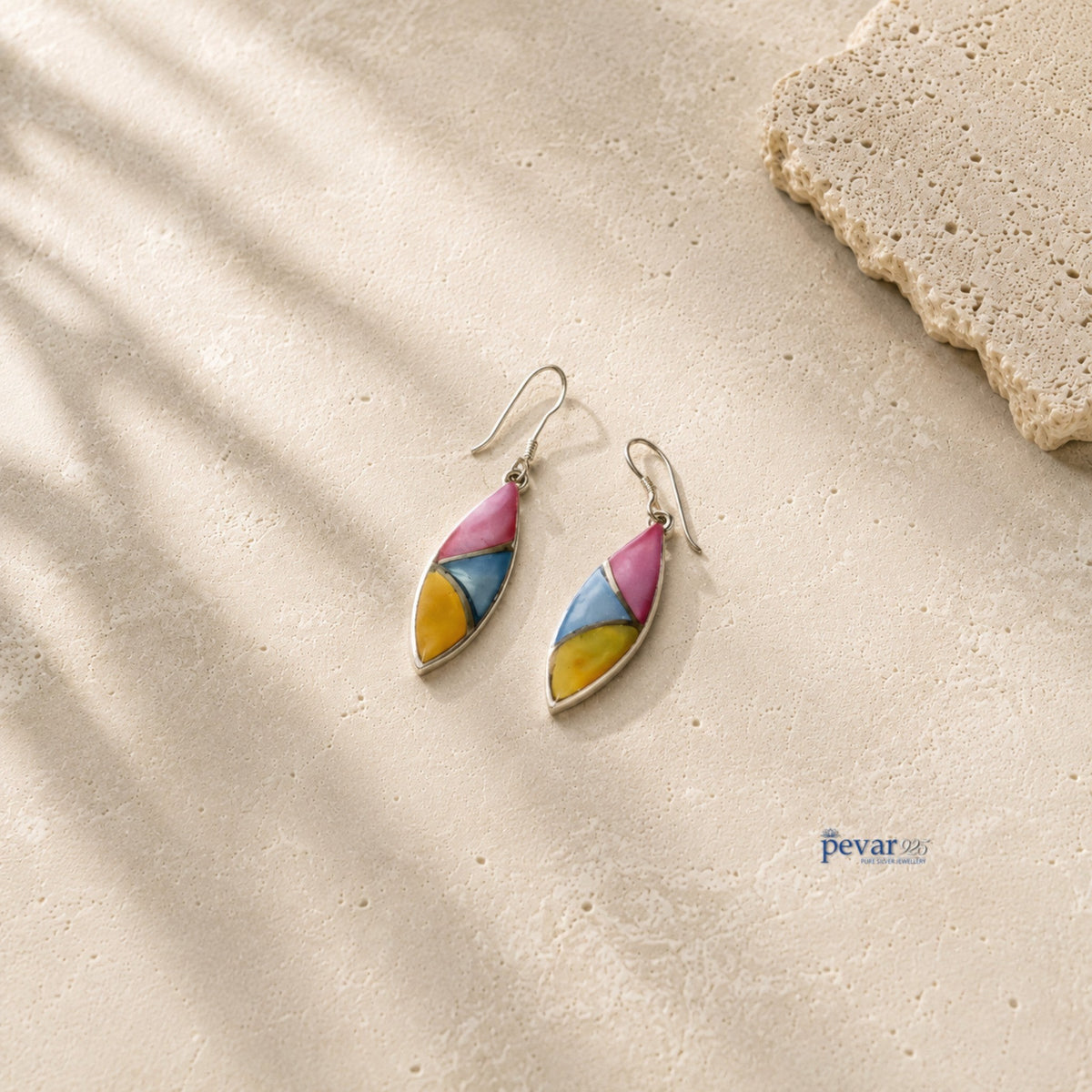 pevar925 oxidized silver hook earrings featuring tri-color leaf motifs in pink, blue, and yellow on a stone surface